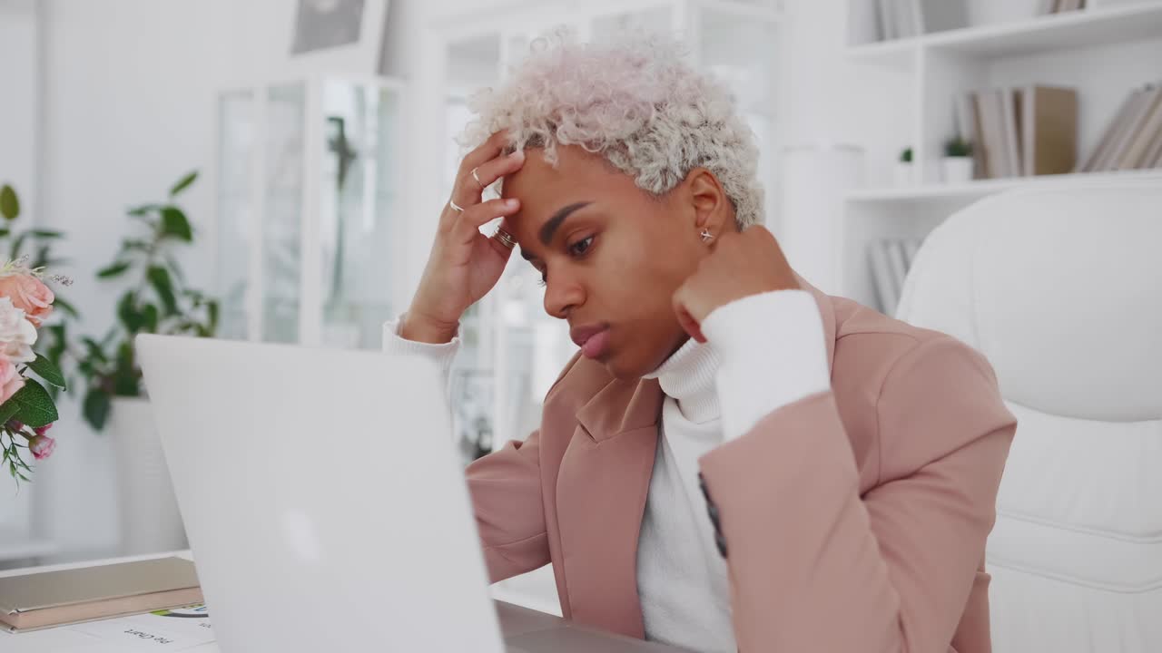 Young african american woman office worker looks at laptop with unhappy face