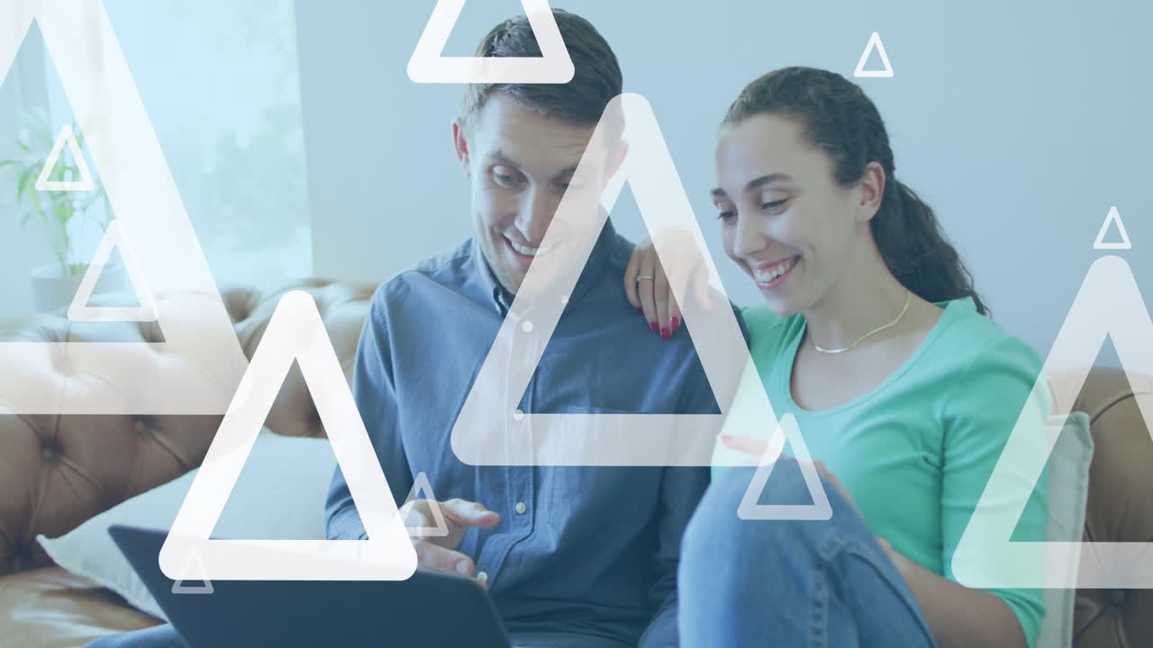 animación de triángulos blancos sobre una pareja caucásica usando una computadora portátil