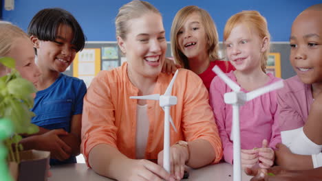 in school, female teacher and students learning about wind turbines in classroom