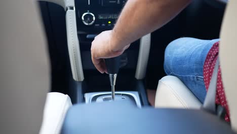 person shifting gears in a car