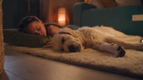 girl and golden retriever sleeping together