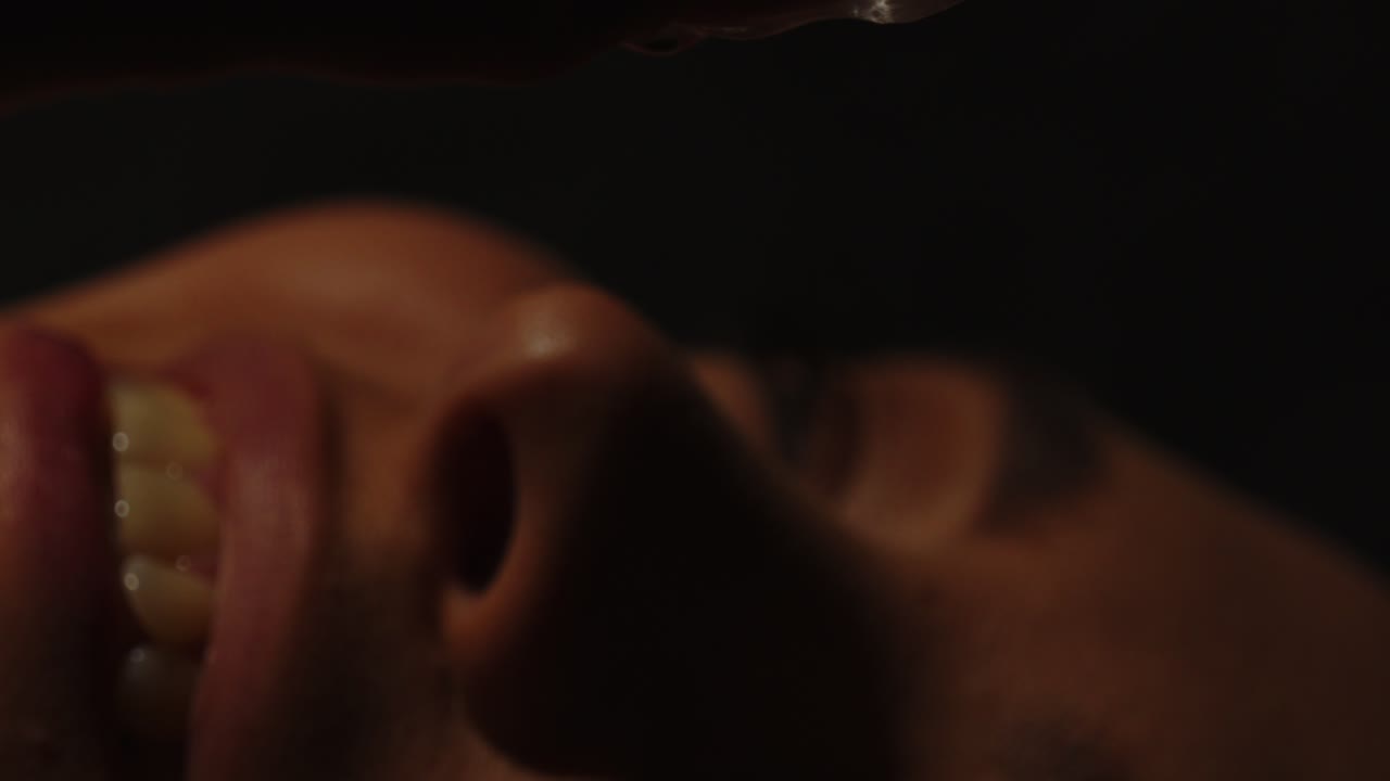 un primer plano de una mujer hermosa poniendo sensualmente un cubo de hielo en su boca