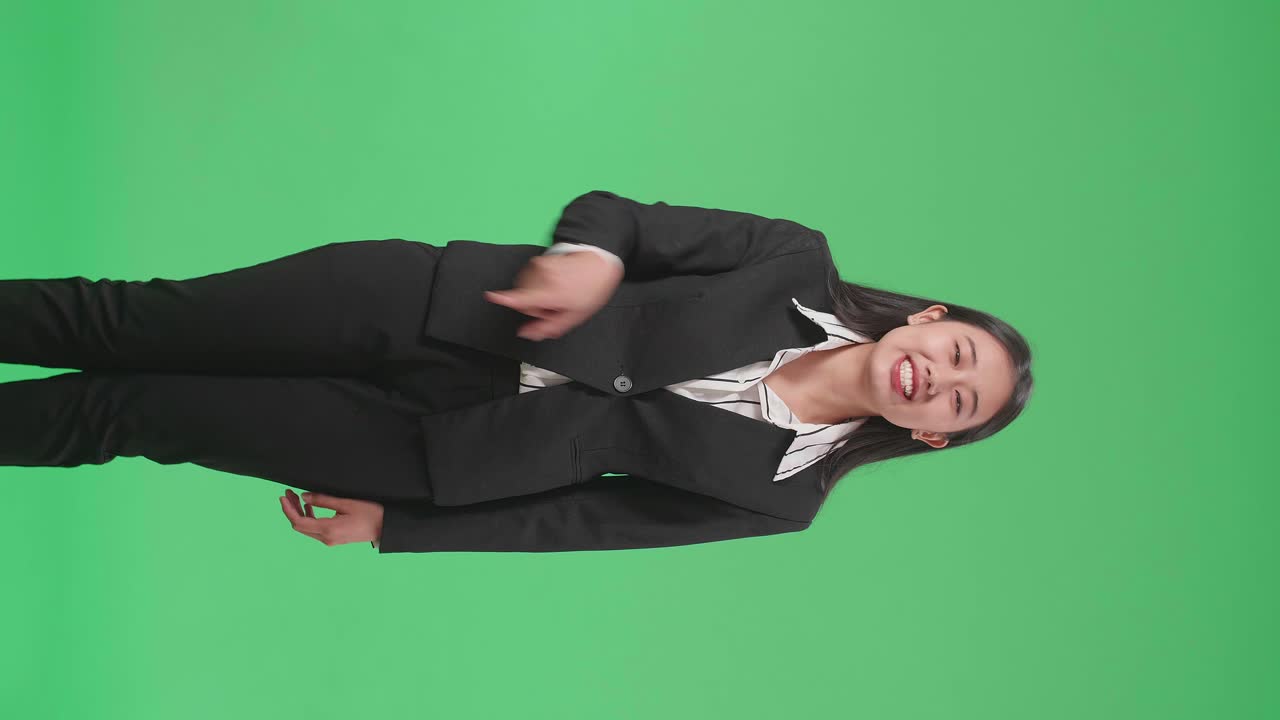 화가 난 아시아 사업가 여성이 스튜디오에서 녹색 스크린에 서서 비난합니다.