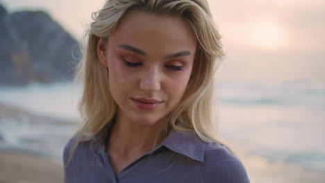 romantic girl posing sunset at ocean shore closeup. gentle smiling woman looking