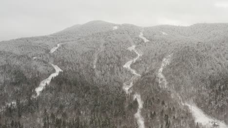 rivers flow through dense mountainous forestry landscape dusted with fresh snow