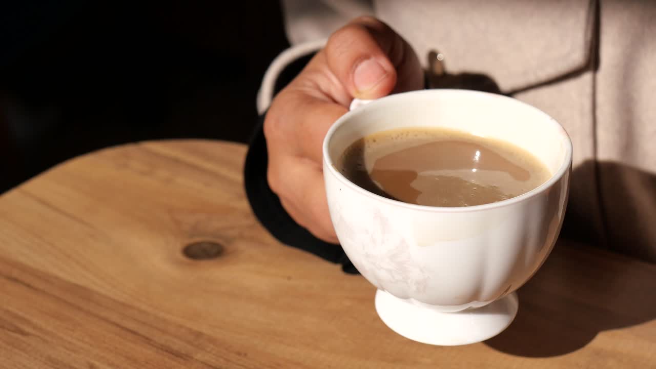 mano con una taza de café