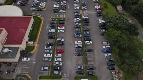 Toma-Aérea-Volando-Sobre-Un-Estacionamiento-Ocupado-Y-Un-Supermercado-En-La-Ciudad-De-San-Jose