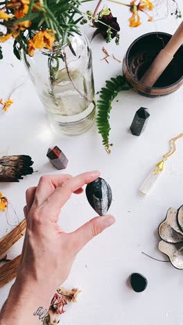 Hand Holding a Crystal with Spiritual Accessories