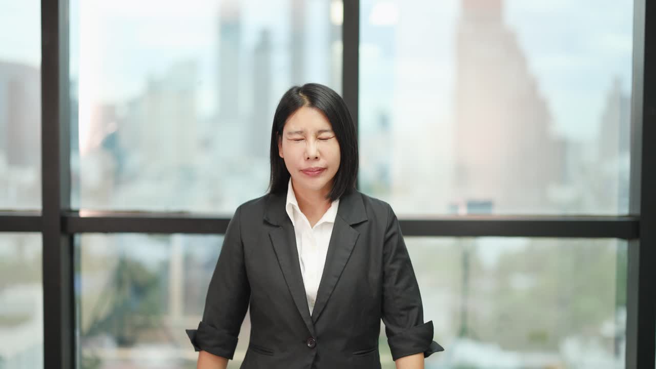 Professional woman in suit crosses arms in front, signaling disapproval, with soft natural lighting