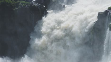 iguazu falls waterfall in argentina, iguacu falls waterfalls pouring off tall rocky cliff, falling water off huge cliff in argentinian rainforest, detailed large splashing waterfall in south america