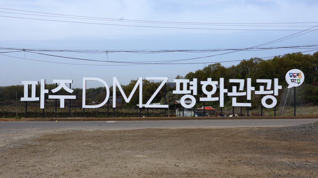 Un cartello lungo la strada segna l'ingresso all'area turistica per la pace della DMZ di Paju, dando il benvenuto ai visitatori nella zona demilitarizzata coreana, una fascia di confine fortemente fortificata che divide Corea del Nord e Corea del Sud