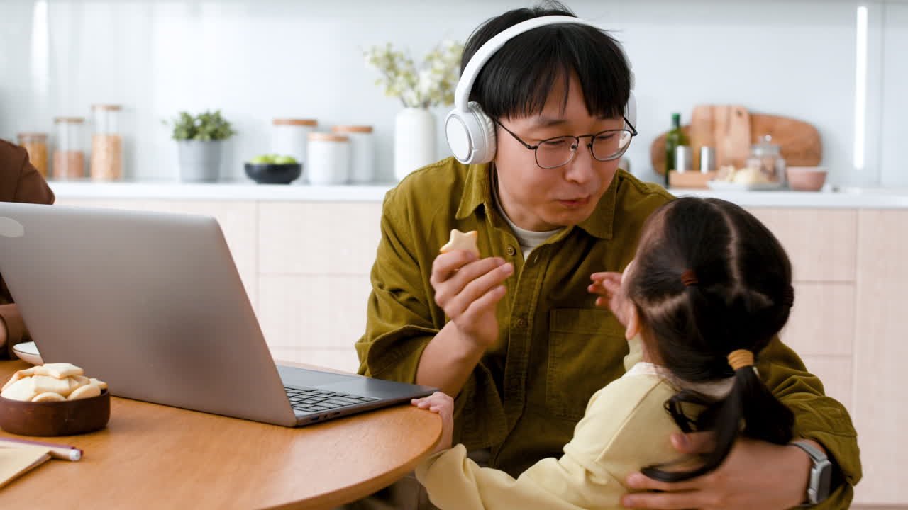 Father and Daughter Enjoying a Snack During a Video Call