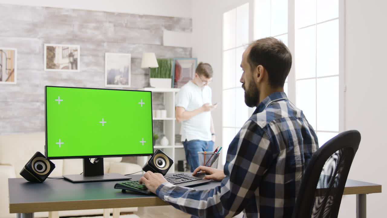 uomo che lavora al computer con schermo verde