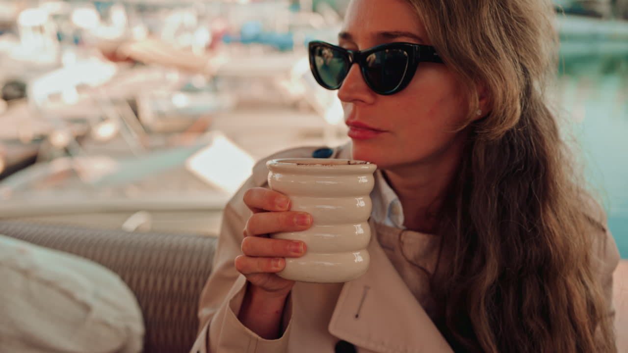 Woman holding a cup of hot chocolate, with cocoa powder visible on top