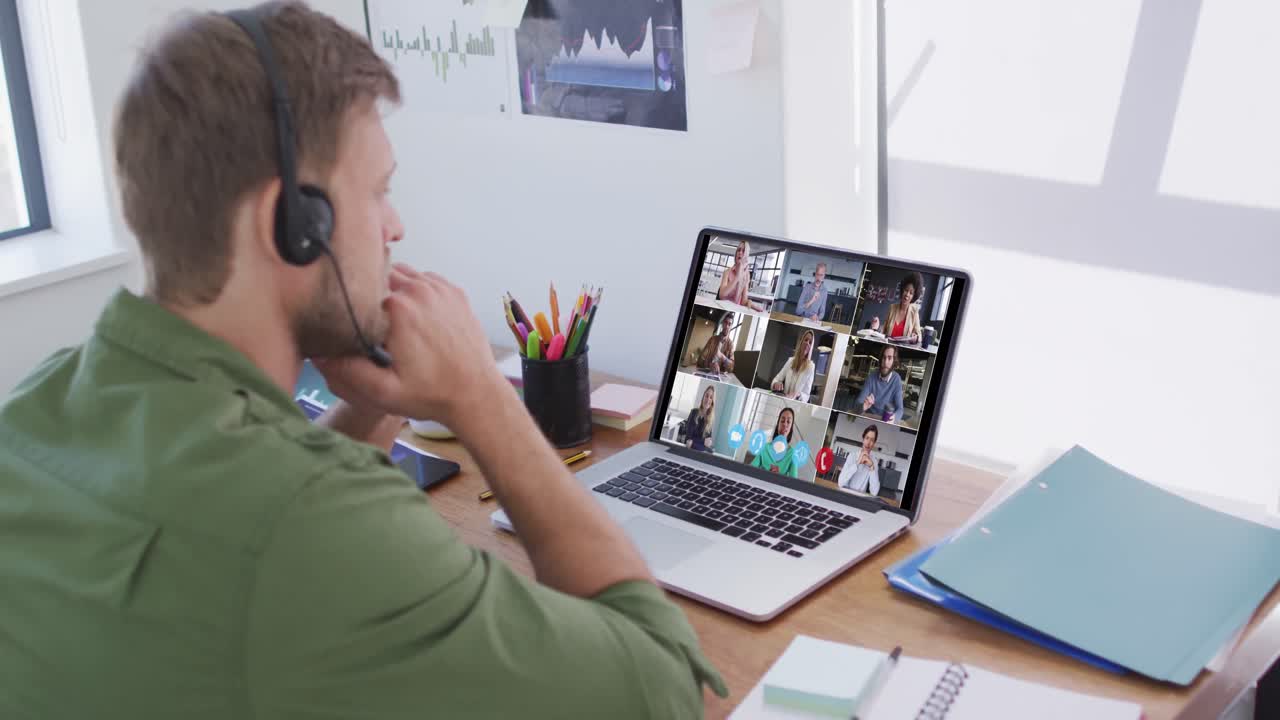 Kaukasisk mand bruger bærbar computer og telefonheadset på videoopkald med kolleger