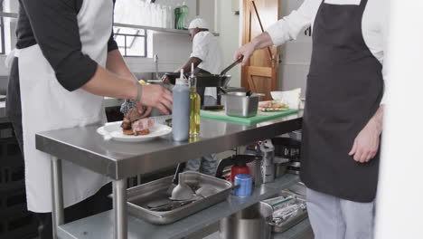 three diverse male chefs preparing meals in kitchen, slow motion