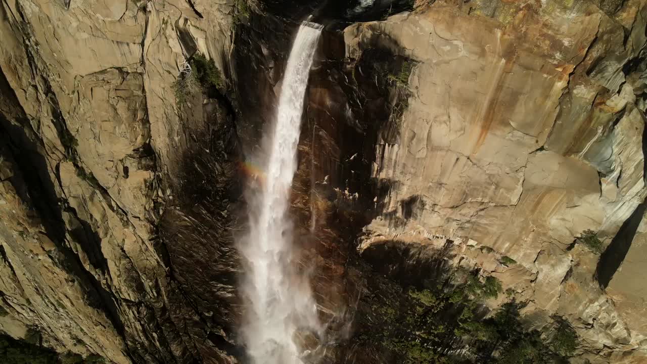 capturar impresionantes imágenes aéreas y de primer plano de la cascada de yosemite utilizando un avión no tripulado, mostrando la majestuosa cascada desde su cima hasta la base de la roca