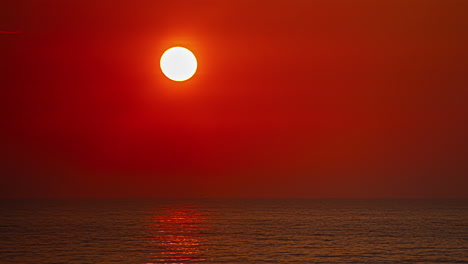 Timelapse-of-glowing-red-sunrise-over-water