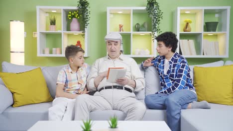 Niños-Escuchando-Atentamente-A-Su-Abuelo-Leyendo-Un-Libro.