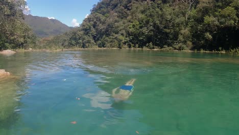 Slo-mo:-Young-man-swims-underwater-in-green-jungle-river-in-Guatemala