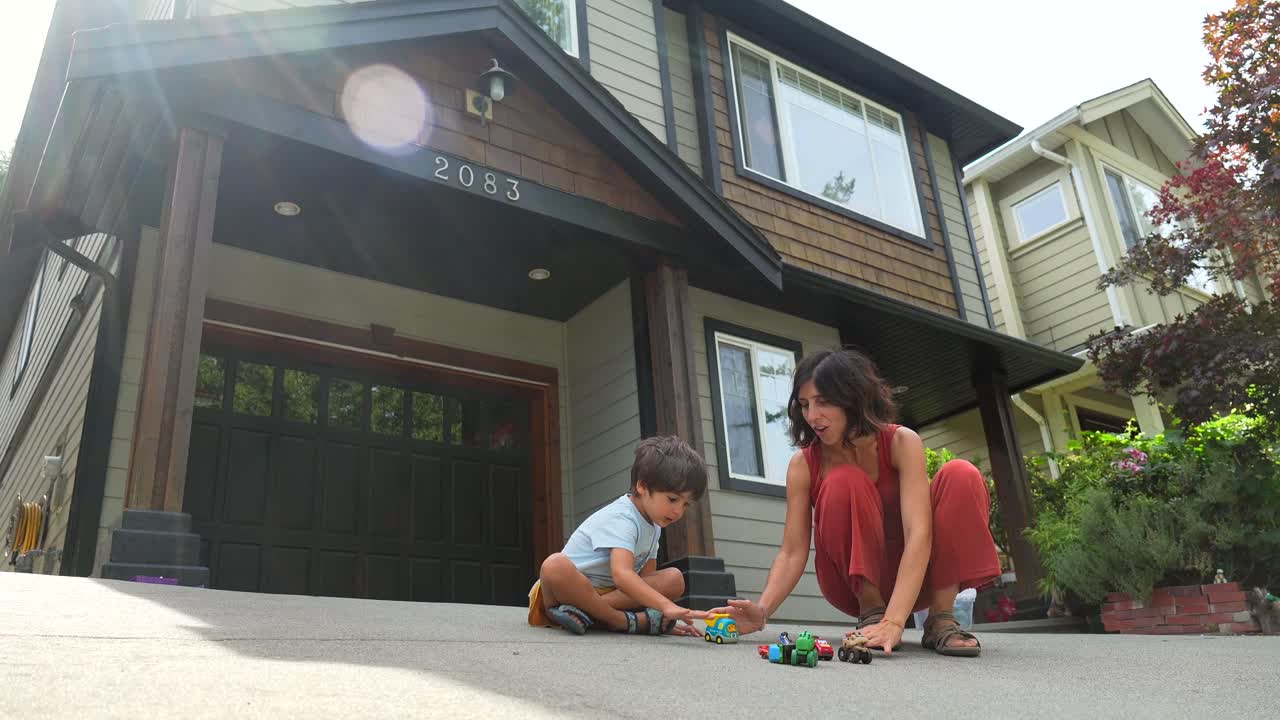 Family playing with toys in front of house