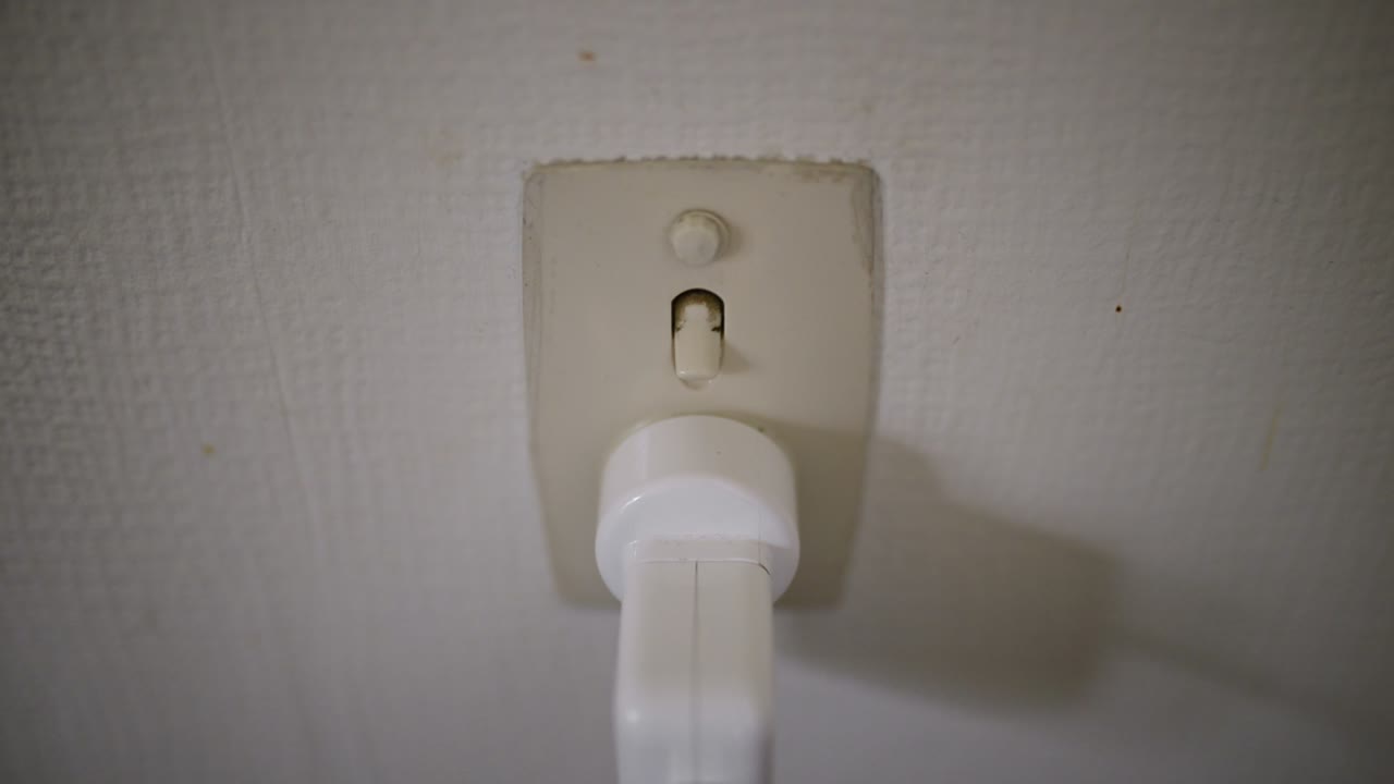 흰색 노트북 플러그를 꽂은 해양 전원 지점을 손으로 켜기