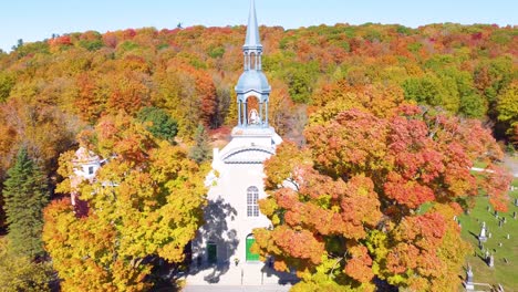 picturesque church and graveyard nestled amidst a vibrant autumn landscape in estrie, quebec, showcasing the beauty of the fall season
