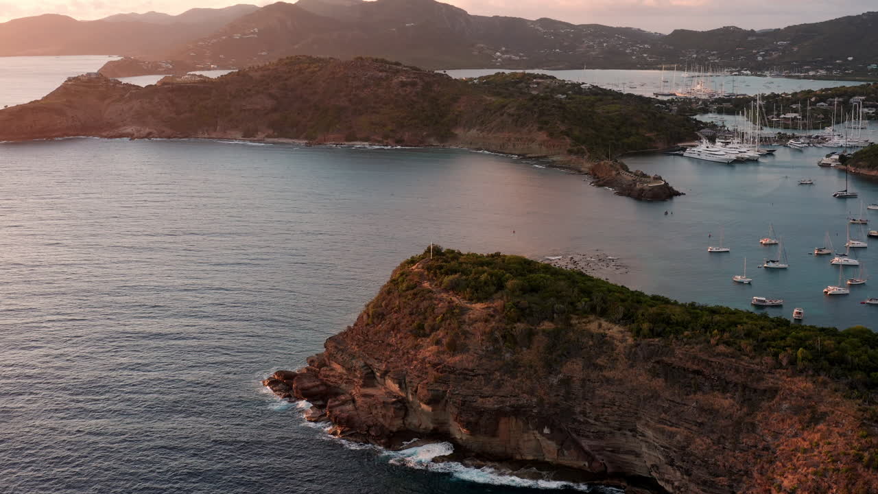 Scatto aereo del tramonto a English Harbor, Antigua, Caraibi, con vista su yacht, barche a vela, porto turistico, baia e scogliere