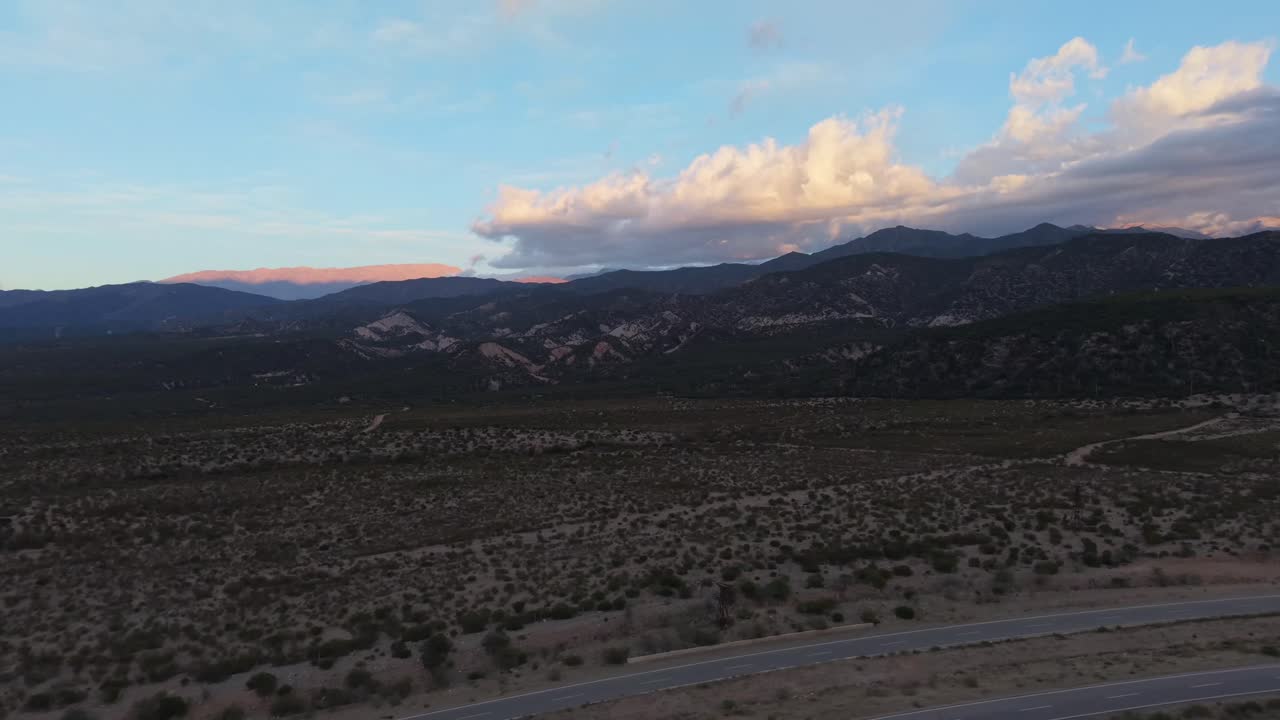 Avenida la Mexicana winds through dry hills and the Chilecito valley, with the Andes on the horizon in La Rioja Province, Argentina