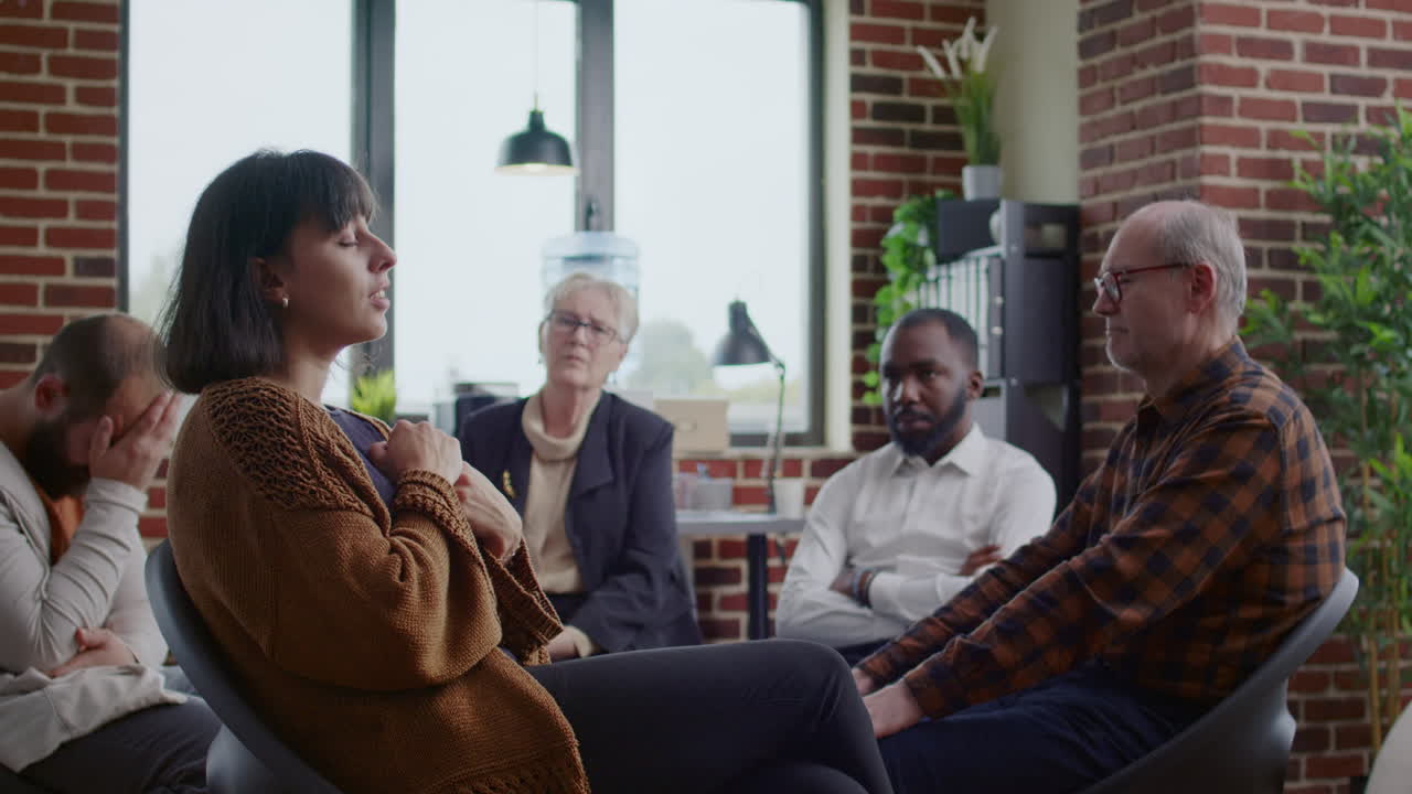 Woman making confession and crying in front of people at aa rehab meeting