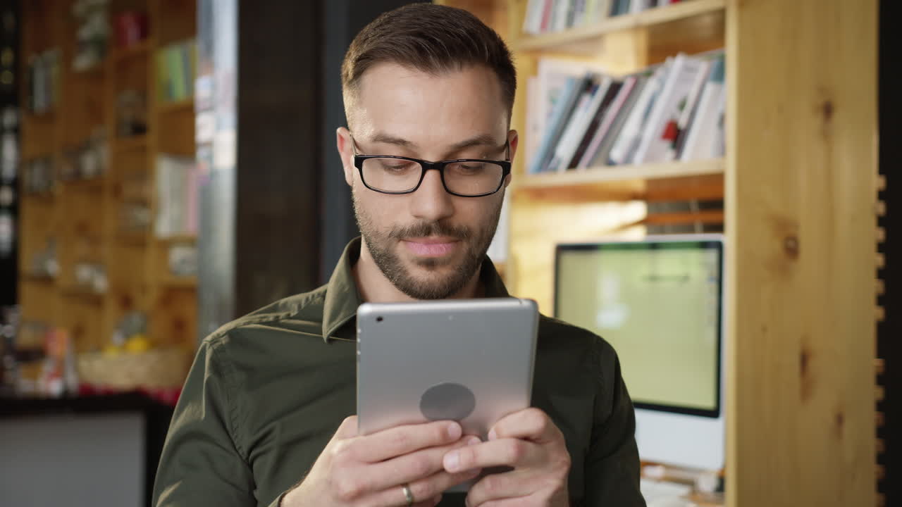 hombre usando una tableta en un entorno de biblioteca