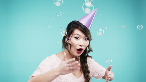 Crazy-face-Asian-woman-dancing-in-bubble-shower-slow-motion-photo-booth-blue-background