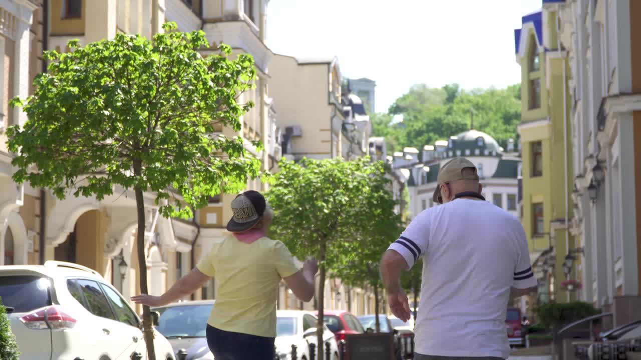 Una donna anziana e un uomo anziano felici, spensierati e alla moda che ballano per strada in città