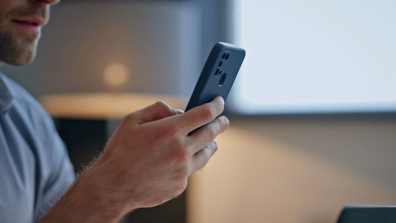 Businessman hands scrolling smartphone in office closeup. Man fingers browsing