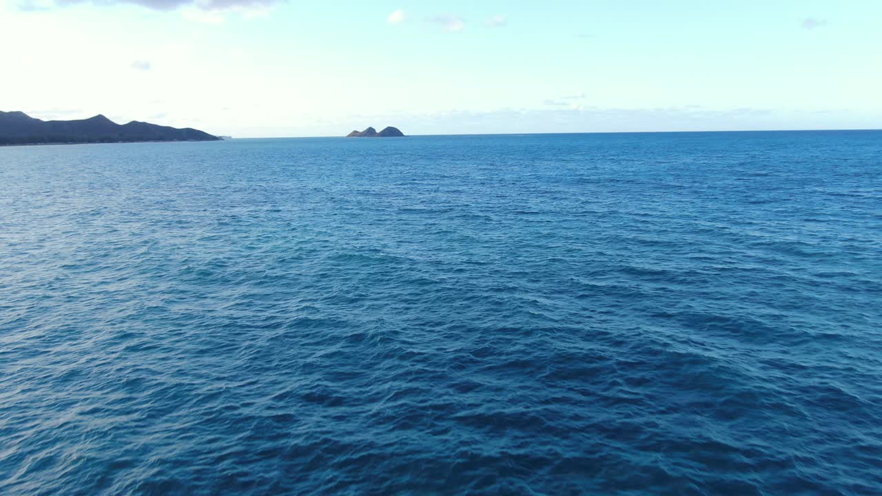 두 개의 작은 섬인 모쿠이키와 모쿠누이에 접근하는 와이마날로 만의 물 위를 낮게 날고 있는 드론
