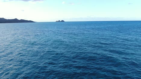 Drone-Volando-Bajo-Sobre-Las-Aguas-De-La-Bahía-De-Waimanalo-Acercándose-A-Las-Dos-Mini-Islas:-Moku-Iki-Y-Moku-Nui