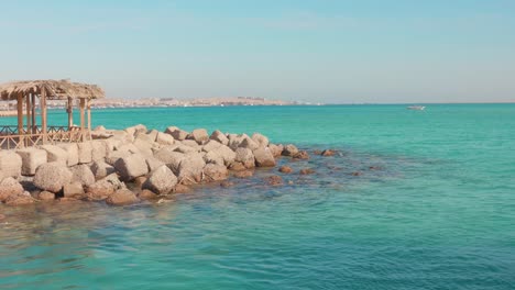 seaside rocks and a thatched hut with turquoise waters in hurghada, egypt, calm vibe