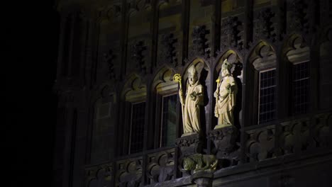 two saints statues lighten in centre of a gothic building bishops holding golden staff in the middle of the night prague, czech republic architecture religious architecture sculptures