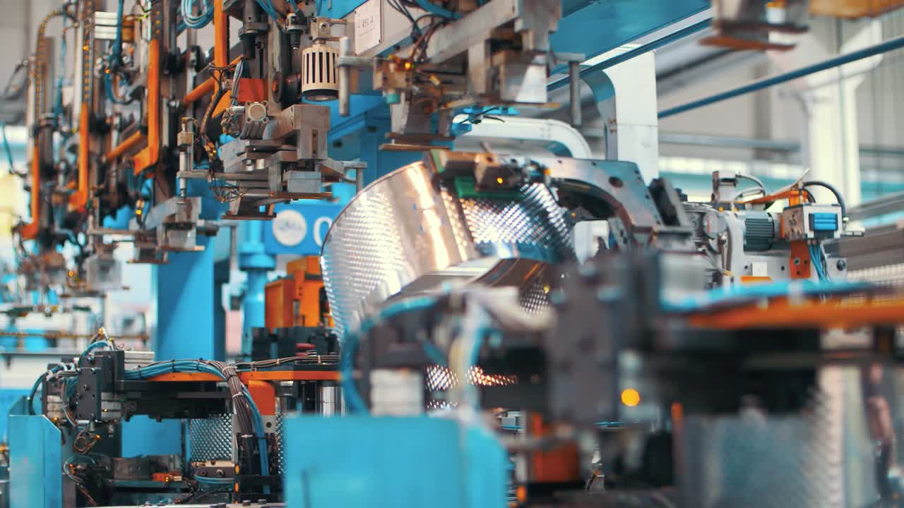Geautomatiseerde apparatuur produceert aluminium trommels voor wasmachines in fabriek.