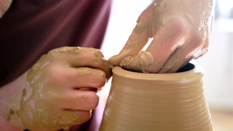 person making pottery on a pottery wheel