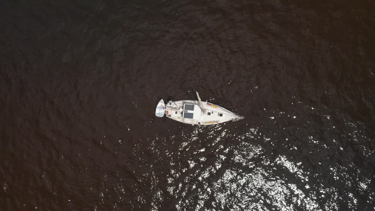 Aerial bird's eye drone shot overlooking the water marina in water sailboat vessel fisherman