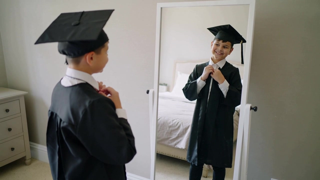 Un ragazzo che sistema il colletto, aggiusta la cerniera della toga e si guarda allo specchio in camera da letto, preparandosi per la laurea e indossando il tocco.
