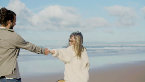 felices recién casados paseando por la orilla del mar en un día soleado