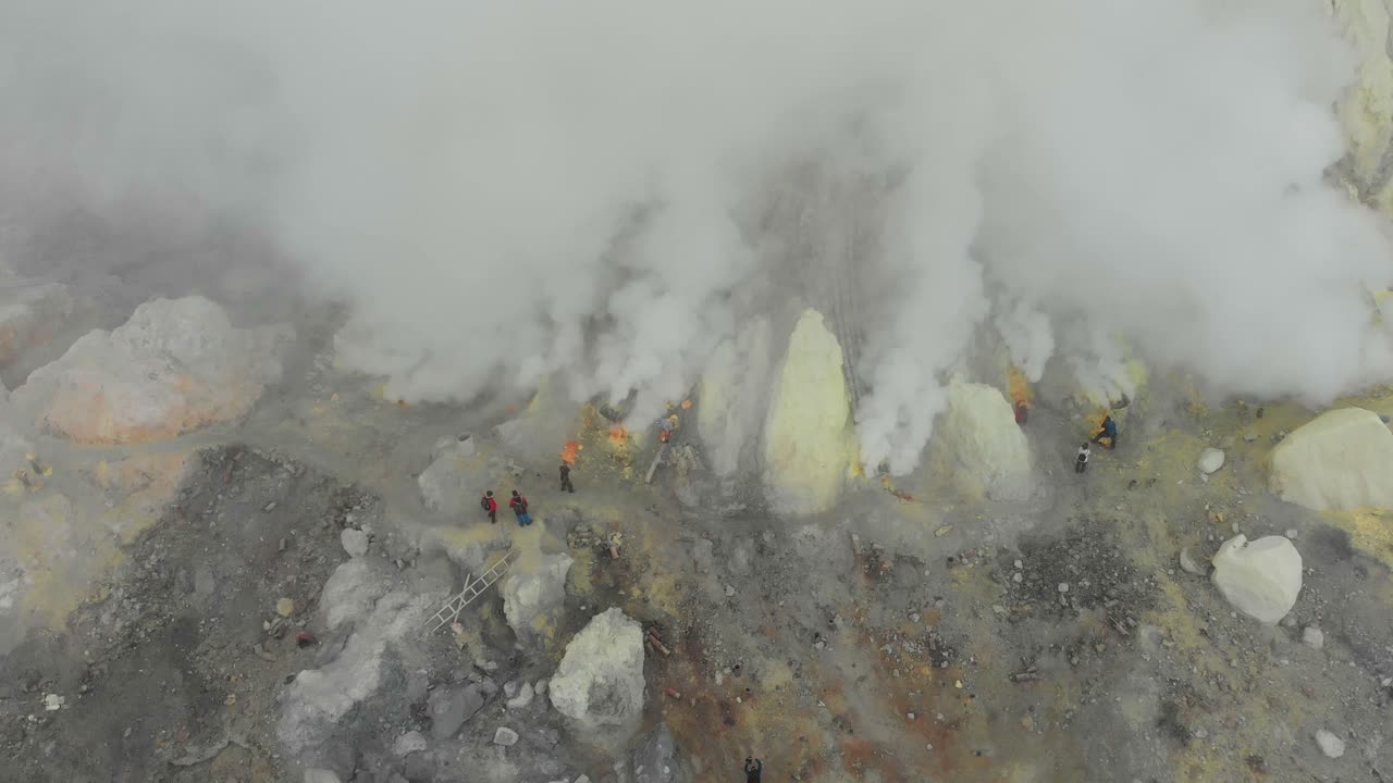 Vista aerea del lago del cratere Kawah Ijen con attività vulcanica e minatori durante l'alba dorata a Giava, Indonesia