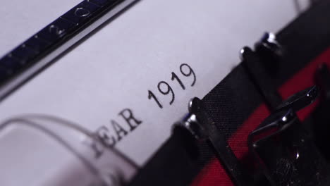 year 1919, typing on vintage typewriter and white paper, macro close up