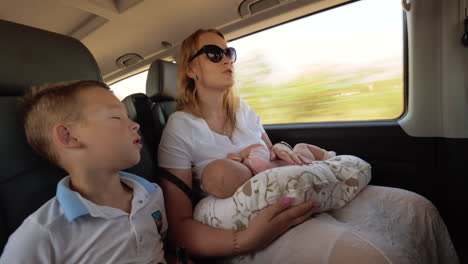 mother with two children traveling by car