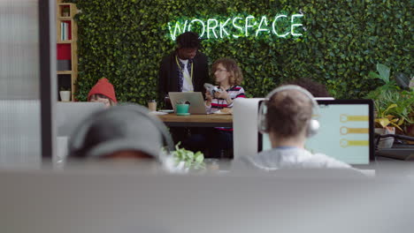 creative business people working in startup office african american team leader man pointing at computer screen showing ideas training intern sharing feedback brainstorming discussing information