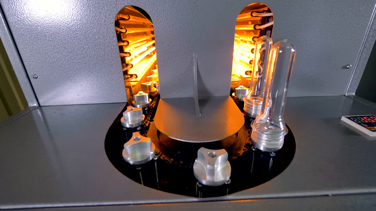 직원이 빈 슬롯에 새로운 플라스틱 프리폼을 설치합니다.