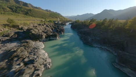 vista aérea paisaje montañoso soleado volando bajo puente peatonal gente turística arroyo de agua de río