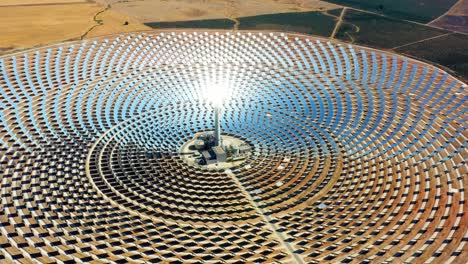 beautiful large circular power plant of solar panels in spain. there is the reflection of the sun in the the panels which produce renewable energy, solar energy - close-up view with a drone - environment concept